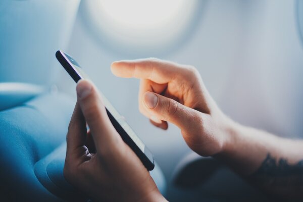 Mão Clicando No Celular No Avião - Perfil RH